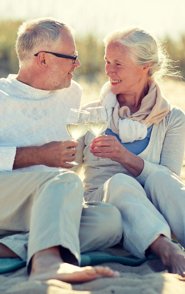 senior couple drinking wine on the beach together successful retirement future cyrstal river fl